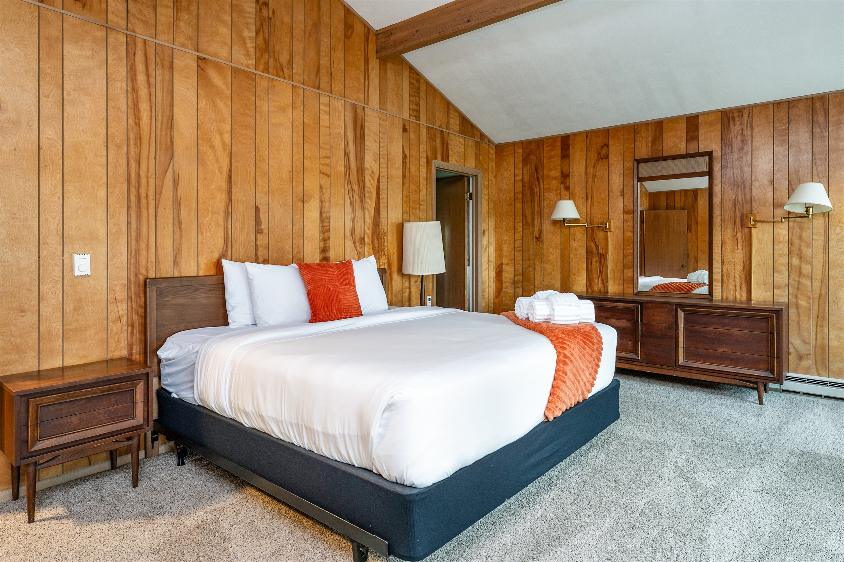Spacious bedroom with a king bed, vaulted ceiling, and direct patio access for fresh air and poolside relaxation.