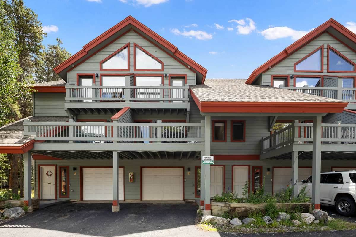 Front exterior of Columbine Pine Creek Retreat in the center with one-car garage, main level balcony and small balcony off the primary bedroom on top level. 
