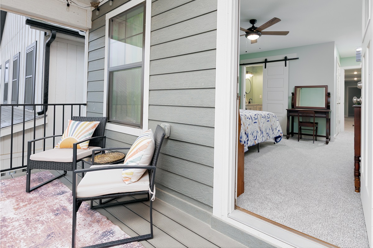 Private balcony off the primary bedroom with comfortable seating for a quiet outdoor escape.