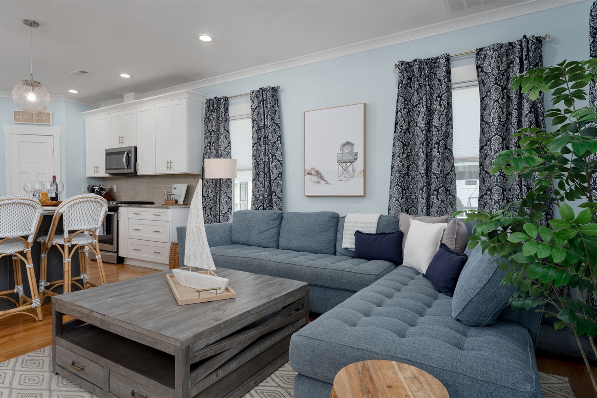 Open-concept living space that flows seamlessly from the kitchen, perfect for relaxing together after a day at the beach.