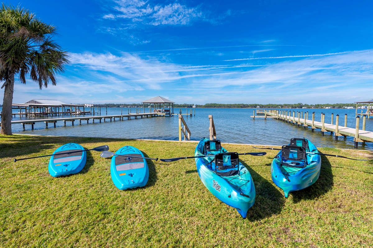 Tranquil lakeside escape: kayak and paddleboard adventures await under clear blue skies!