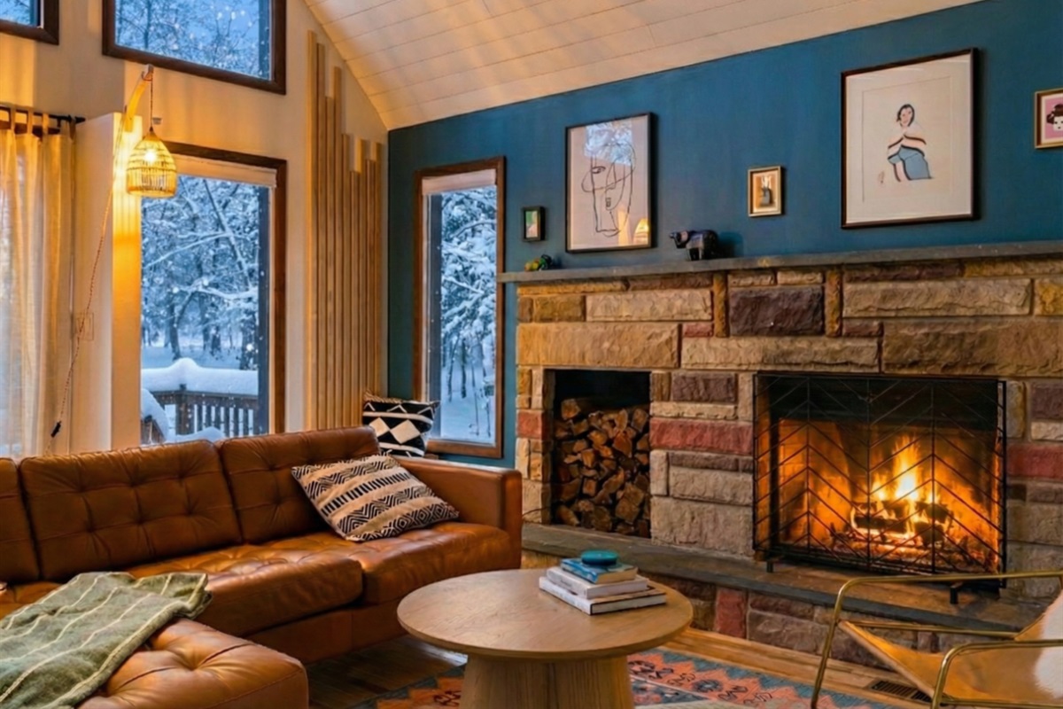 Get cozy after a long day of skiing or activities - comfy leather couch and stylish furniture around a wood-burning fireplace