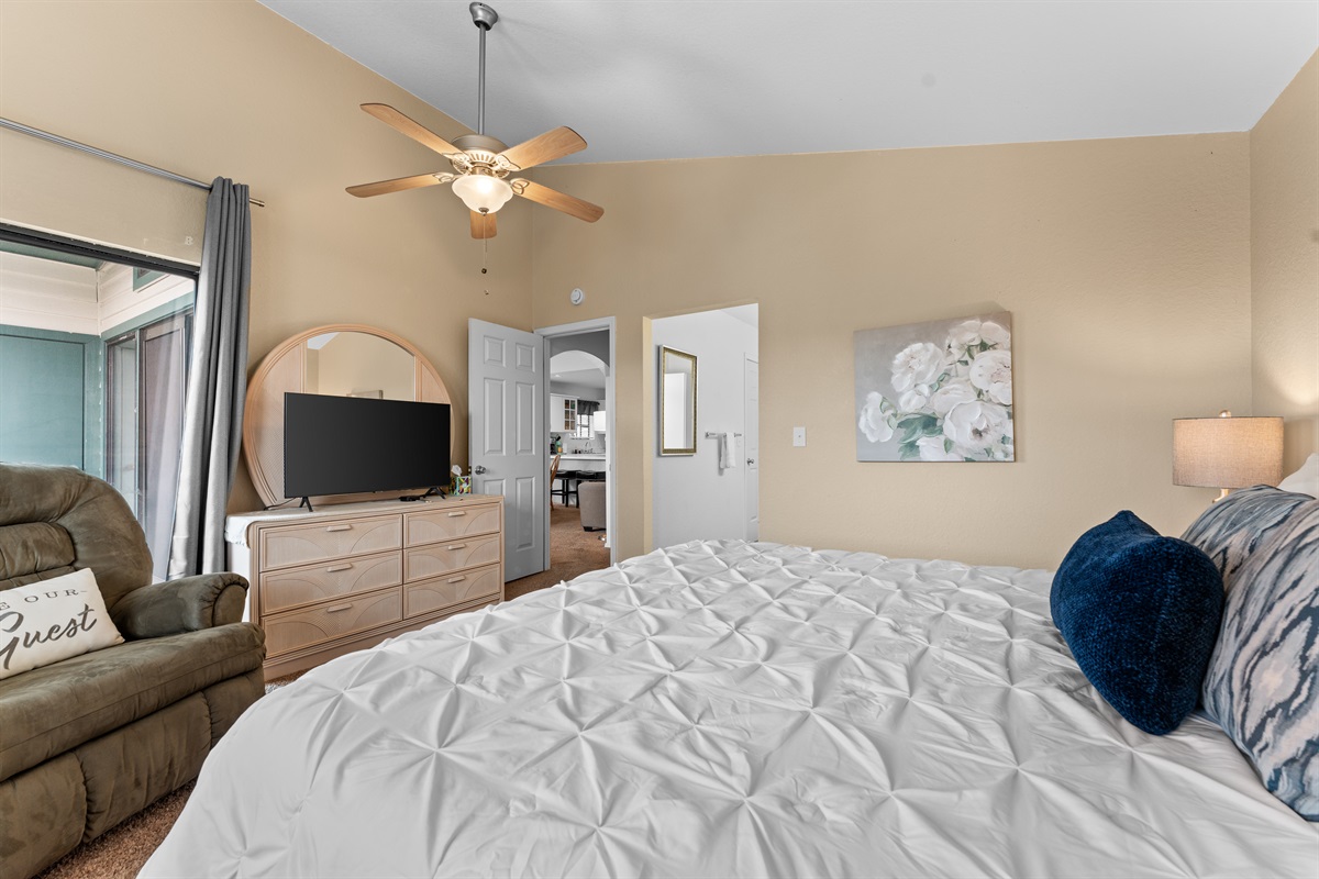 Another angle of the king primary suite, showing the generous floor space and en-suite access.