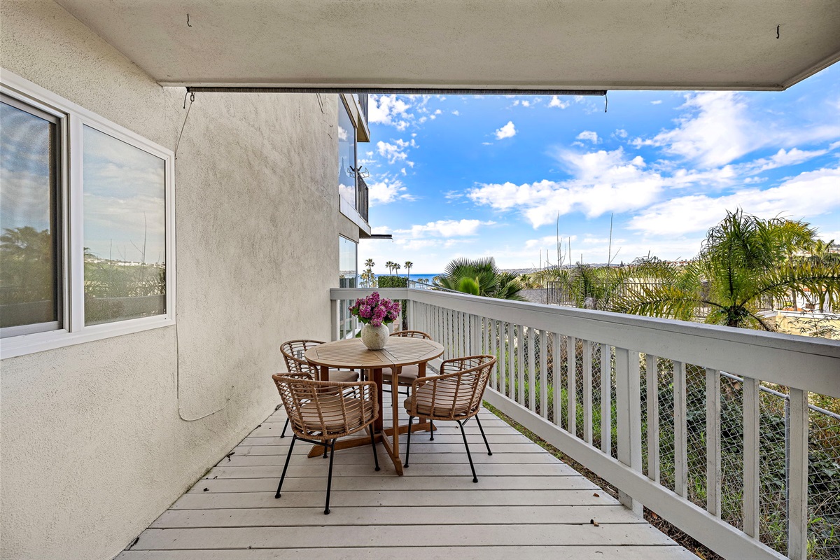 Private deck off the primary bedroom with a bistro table