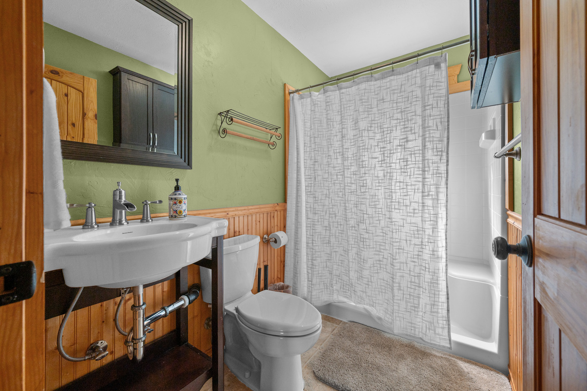 Upper full bathroom with vanity, toilet, and walk-in shower.