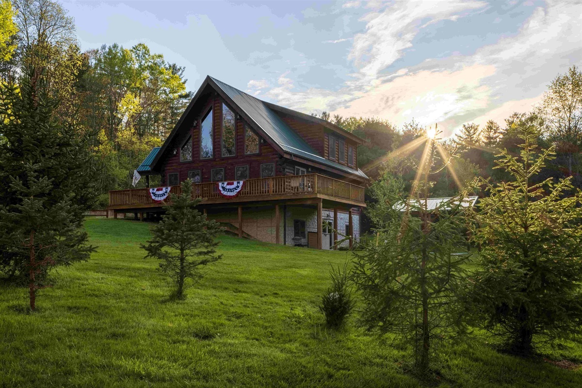 The Lodge has a small grassy area surrounded by woods.