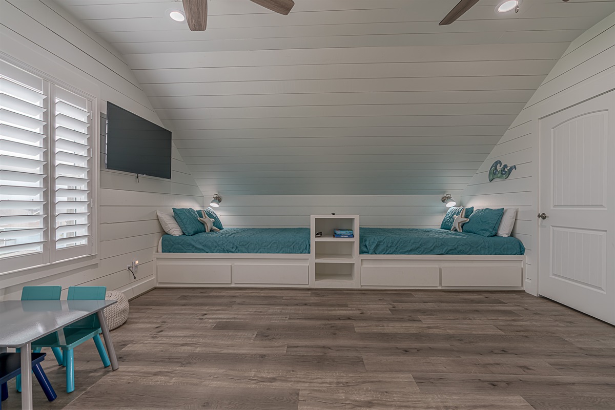 Storage doors beneath the beds and shelving between them.