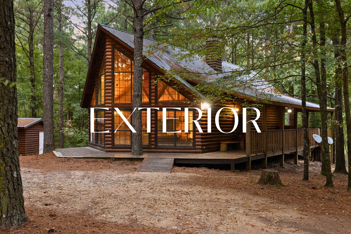 Side view of cabin showing rustic charm and forest setting