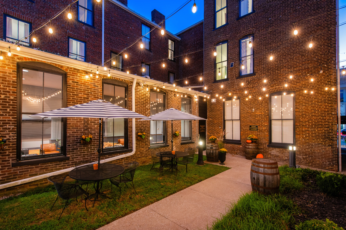 The shared hotel courtyard at dusk, with outdoor tables and string lights.