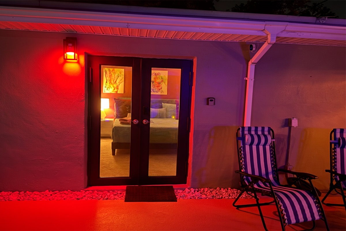 Private exterior entrance to The Red Room at night, featuring ambient lighting and a direct connection to the pool area.