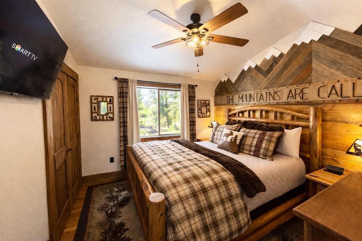Main floor bedroom | Queen bed. Equipped with a Smart TV, premium pillows/linens, room-darkening curtains, ceiling/window fans, charging stations, bedside lamps, extra blankets and pillows.