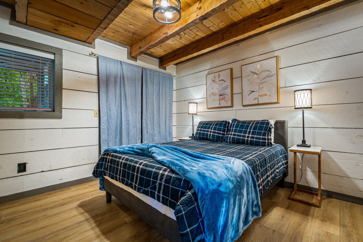 Lower level bedroom, with queen bed, nightstands, dresser, smart TV, and closet.