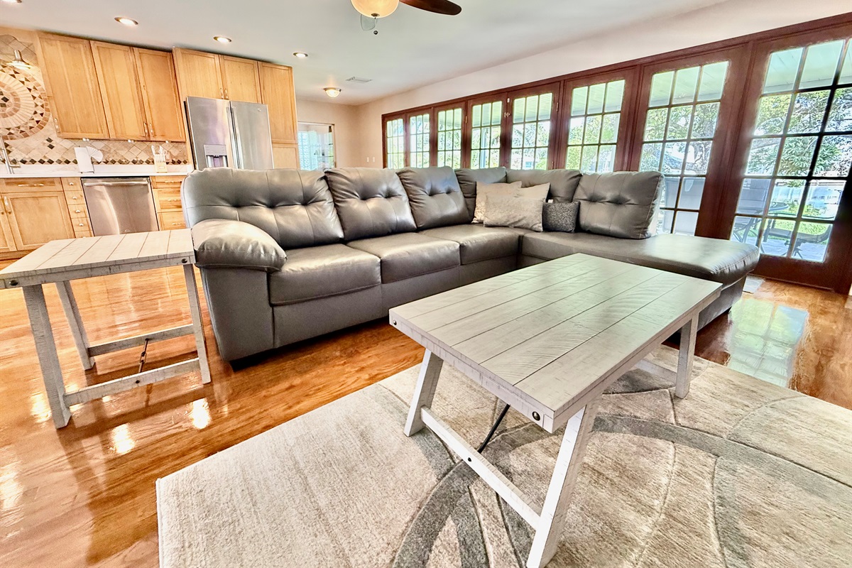French doors line the back wall, filling the room with light and offering beautiful views, while cozy seating and modern decor invite you to kick back and relax.