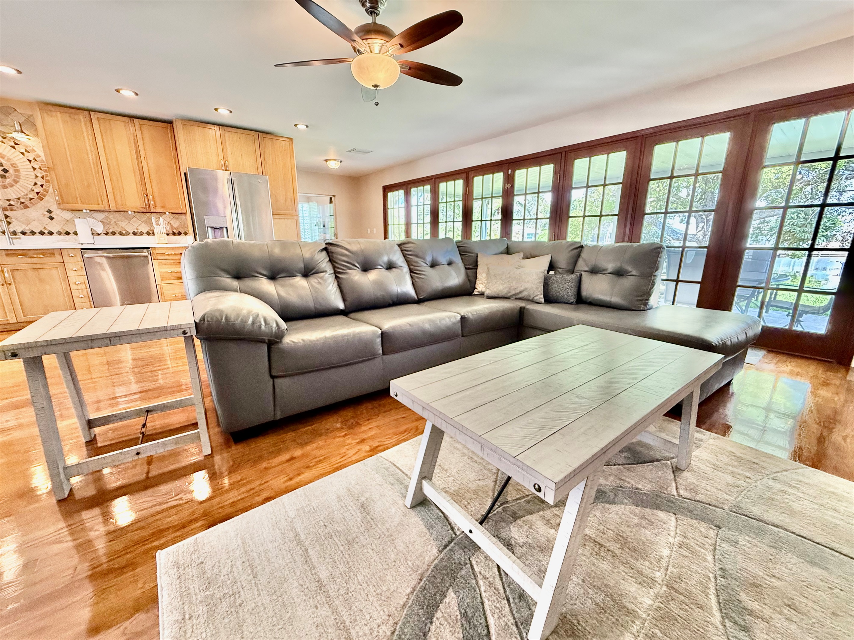 French doors line the back wall, filling the room with light and offering beautiful views, while cozy seating and modern decor invite you to kick back and relax.