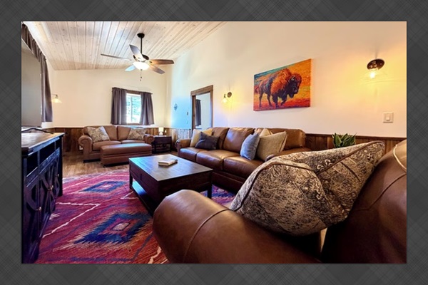 Elk Suite living area featuring leather sofas with a queen sofa sleeper and smart tv.