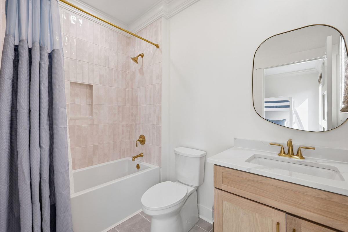 First-floor bathroom #2 with tub-shower combo and gold fixtures