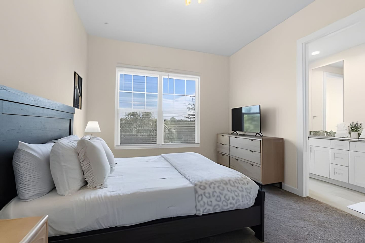 Well-lit bedroom with large windows offering beautiful views!