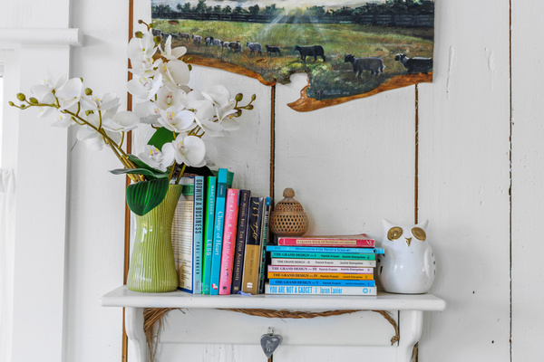 Shelves throughout the carriage house hold invitations to get curious, find inspiration or spend an afternoon happily lost in a few pages. (Art painted by a inspired guest of her view of the pastures one morning!)