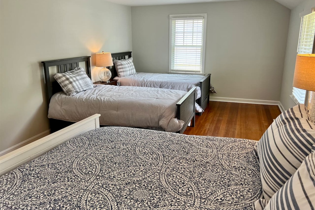 First bedroom with two twin beds and a queen!