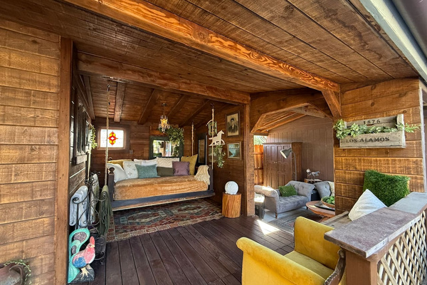 The covered porch unfolds like an outdoor living room, with intimate seating nooks, vintage finds and the full-size Bali swing bed. Grab a blanket, cue up karaoke or challenge someone to paddleball—then claim your corner and stay awhile.