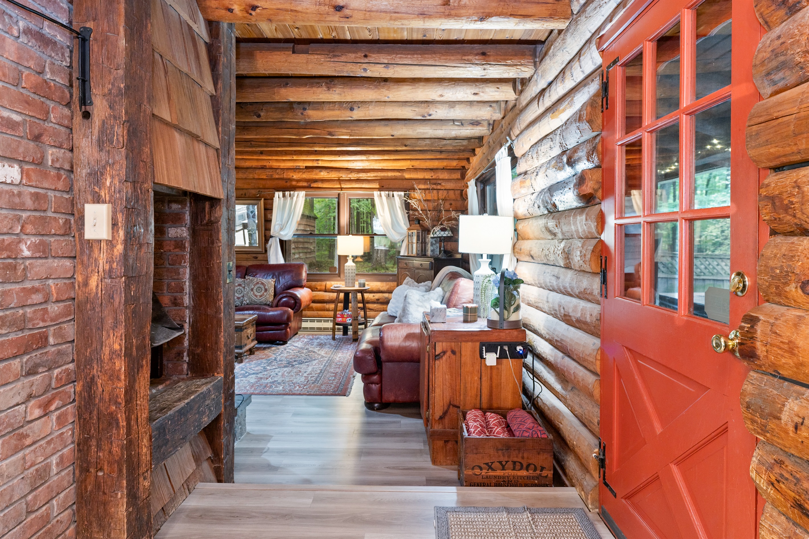 Step into rustic charm with exposed log beams, cozy seating, and a warm cabin vibe perfect for relaxation.