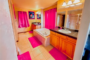 A private ensuite bathroom for the master's bedroom upstairs, featuring double sinks and a tub for comfort