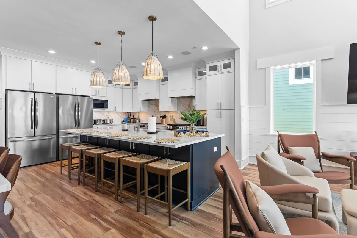 The heart of the home. This open-concept kitchen connects seamlessly to the living and dining areas, while the adjacent oceanfront deck offers additional seating for meals with a view.