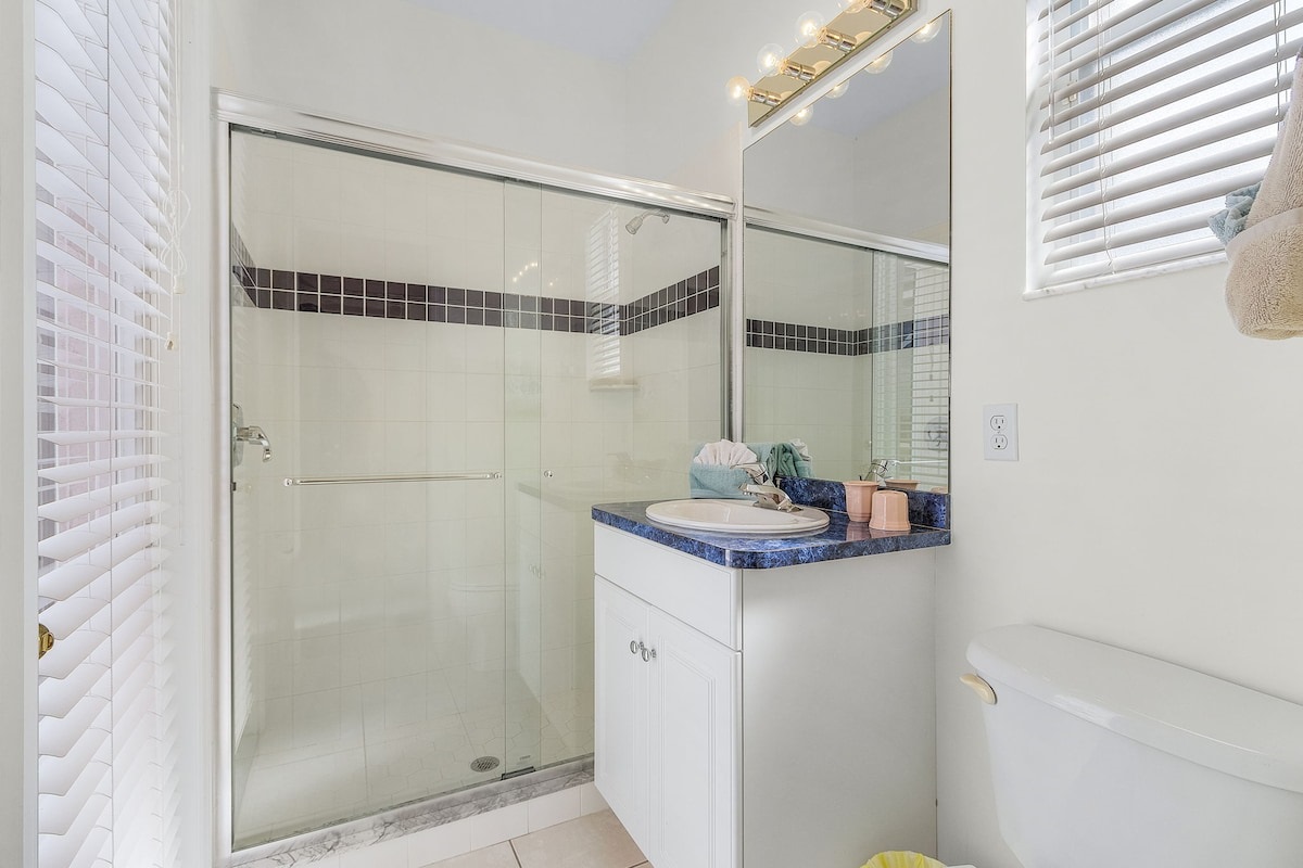 1st Guest ensuite bathroom featuring a shower and direct access to the pool and lanai area!