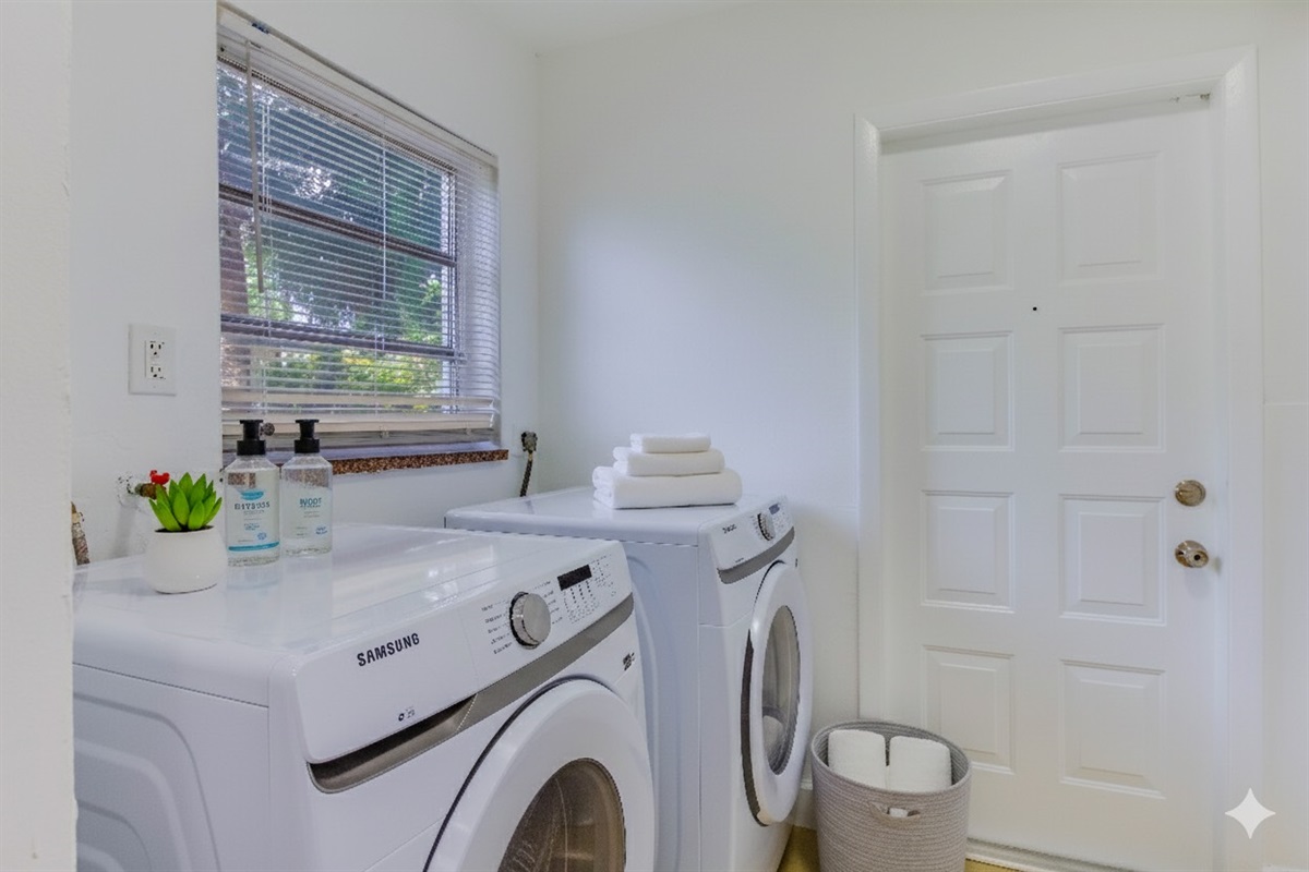 Convenient laundry area with modern washer and dryer, fresh towels, and essentials provided.