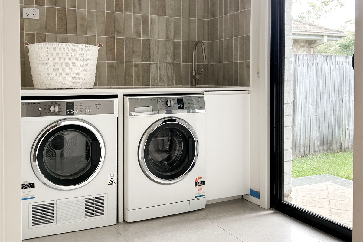 The laundry has a front-load washer, separate dryer and bench space, making everyday washing simple during the stay.