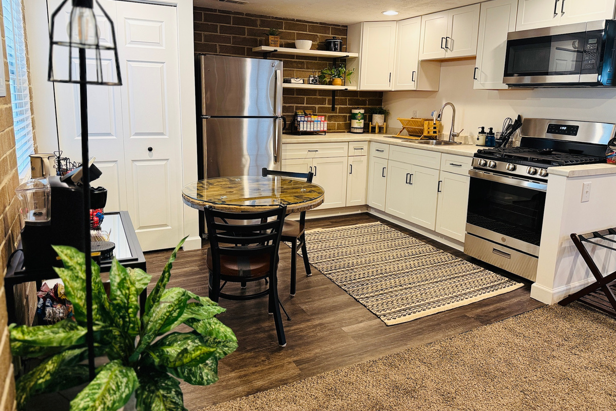 Full kitchen with a gas range, refrigerator, microwave, and dining space.