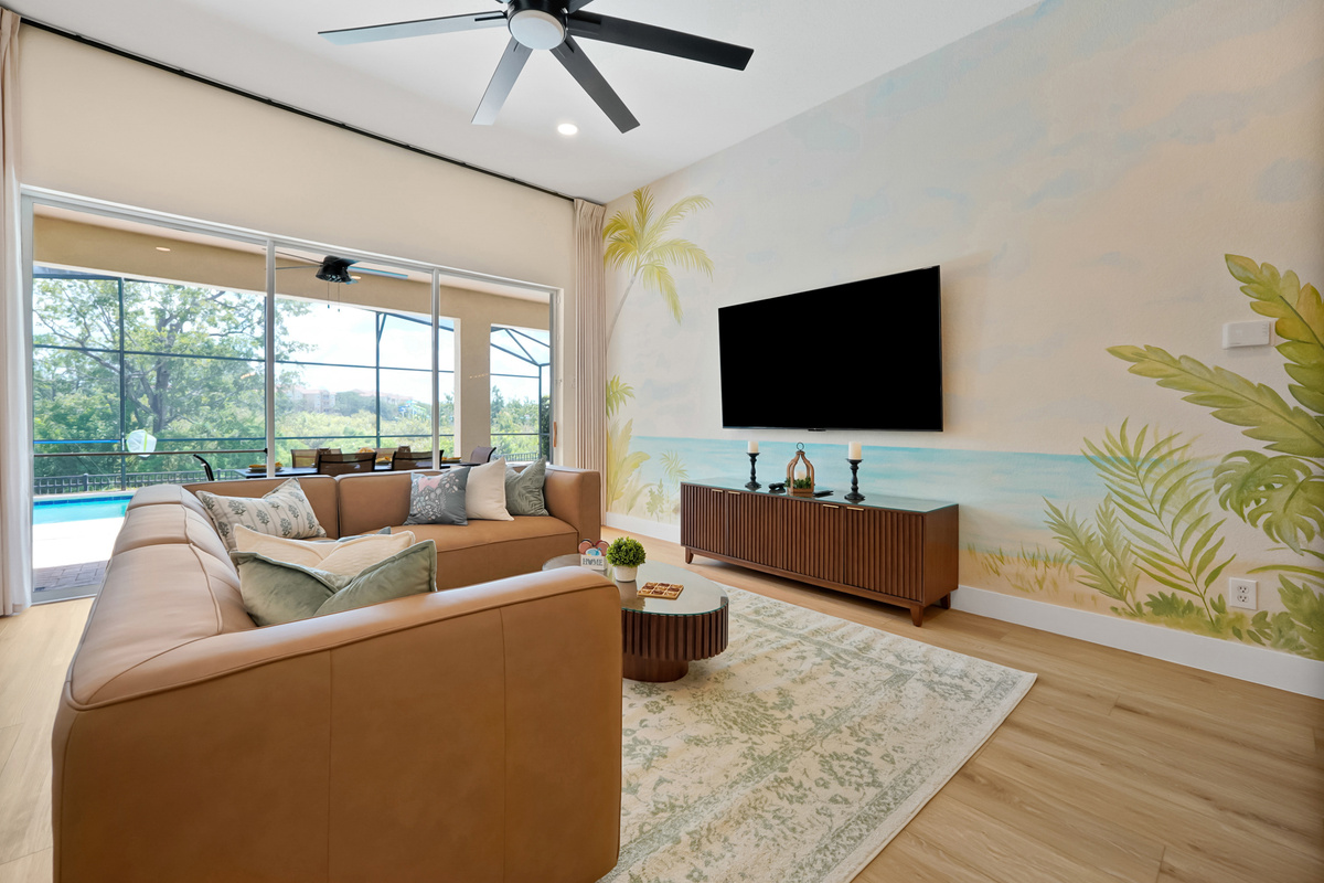 Living Room: Spacious tropical-inspired living area with 75" Smart TV and direct access to the private pool.