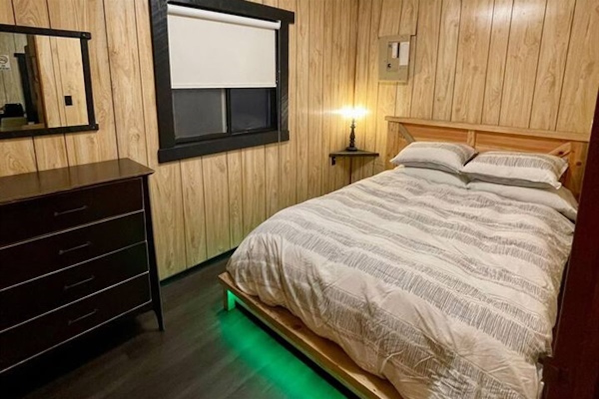 Comfortable bedroom with dresser and warm wood finishes
