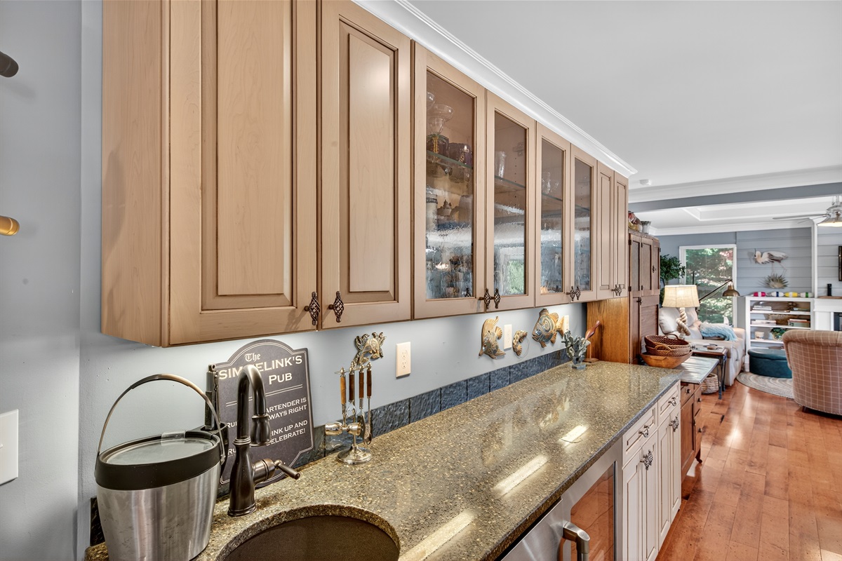 This custom bar space adds function and charm with its prep area, sink, and sleek under-counter amenities.