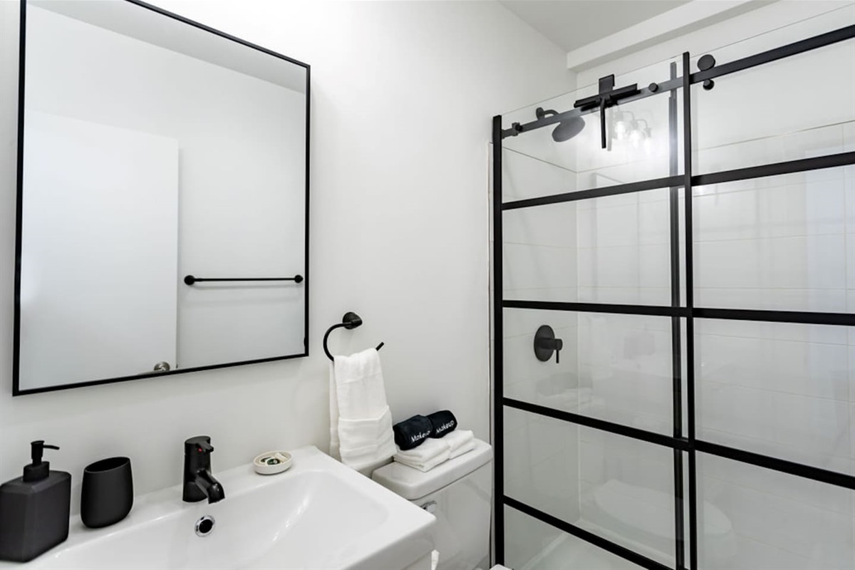 Stylish white and black interior full bathroom, combining modern design with functionality.