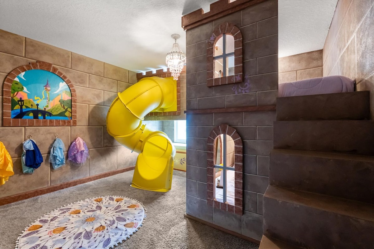 No princess bedroom is complete without a spiral slide, am I right? Let the littles enjoy some princess time in the Tangled themed castle bedroom with dress up clothes, spiral slide, a bench with beautiful lake views and a princess soundtrack.