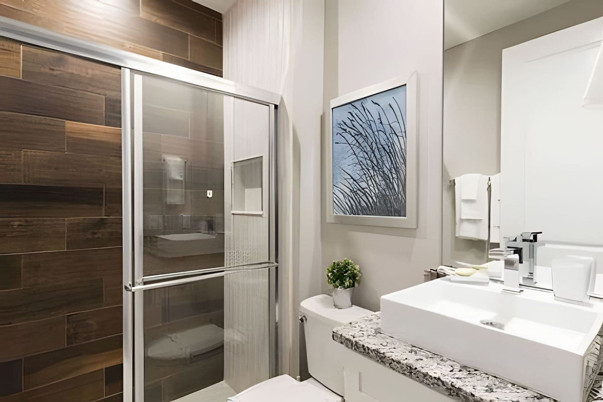 Private bathroom with sleek finishes, large shower, fresh towels, and thoughtful amenities.