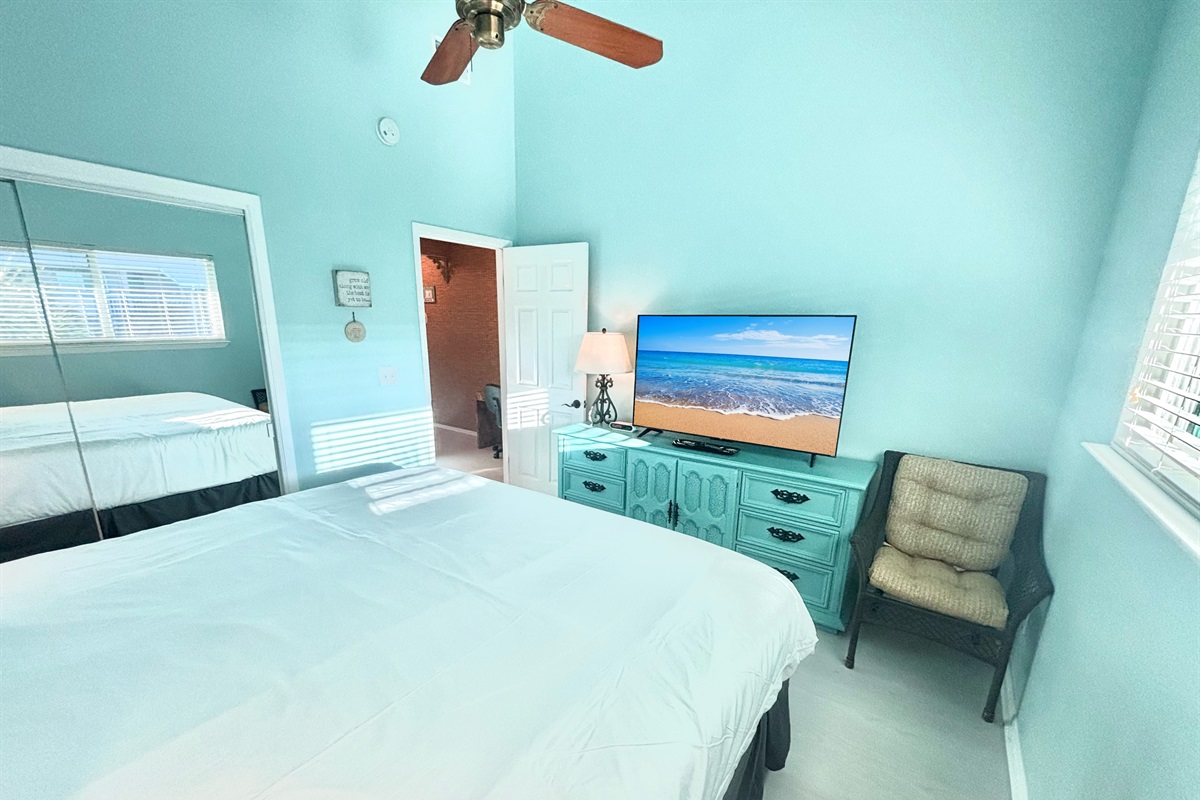 Spacious master bedroom with large TV