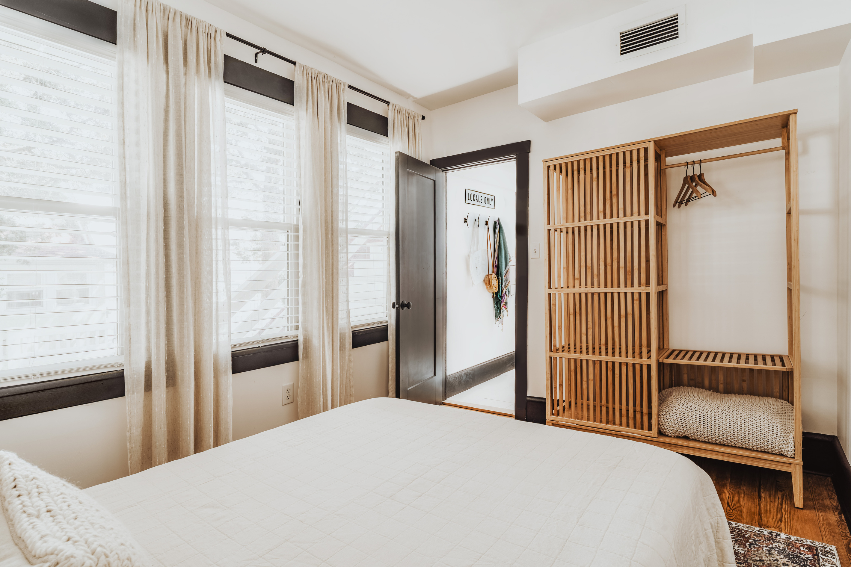 Bedroom 3 View Highlighting Large Windows with Curtains, Slatted Closet, and Open Doorway