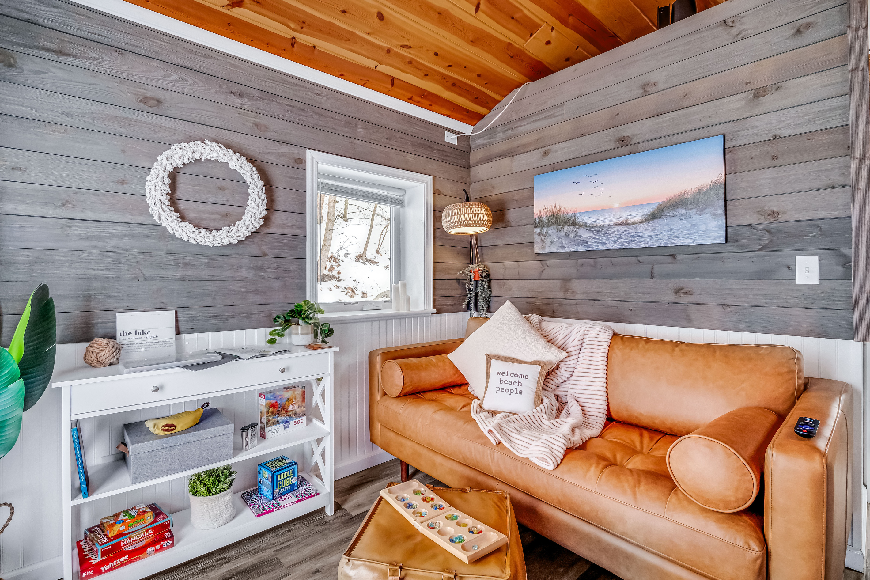 Duet Cottage - The living room offers a comfortable leather sofa and a curated selection of games, ideal for relaxing and enjoying quality time together.