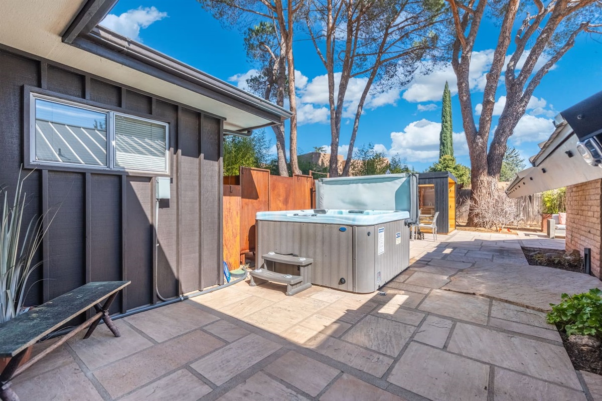 Secluded spa patio with privacy fencing and spacious stone decking — ideal for relaxing in total comfort.