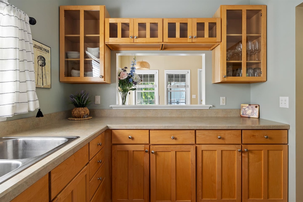 Dinnerware is available in glass cabinets and in cabinet by fridge. Pass through window ideal for serving and seeing your family and friends while dining.