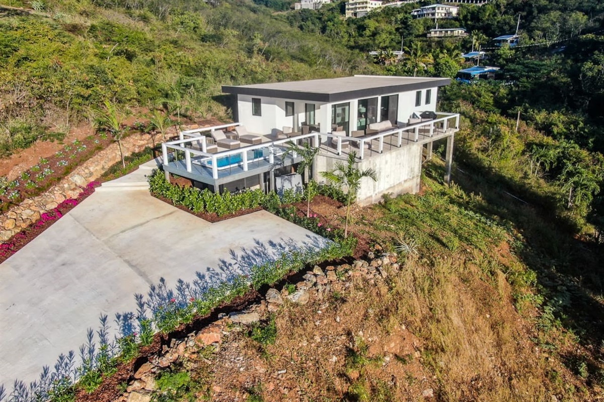 Elegant villa facade surrounded by lush landscaping.