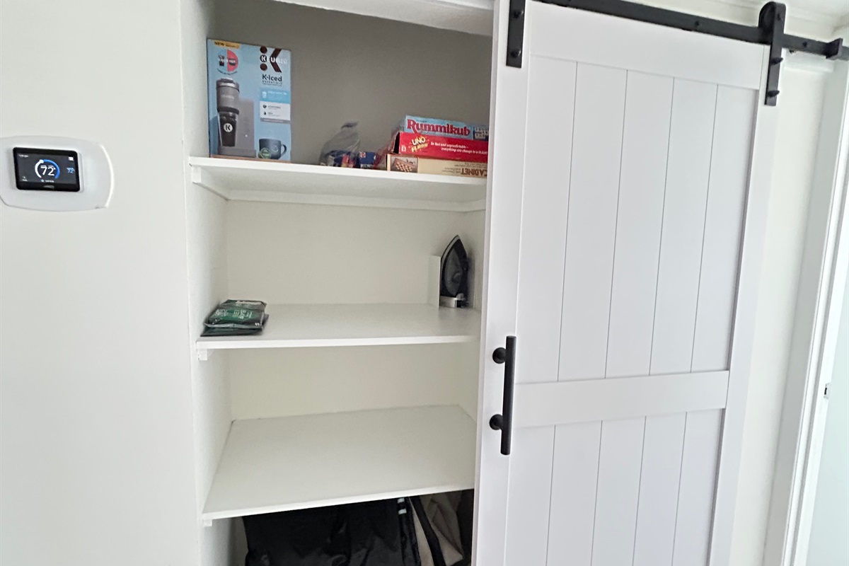 Hall Closet with Barn doors offers storage space and an air mattress in the bottom of closet.