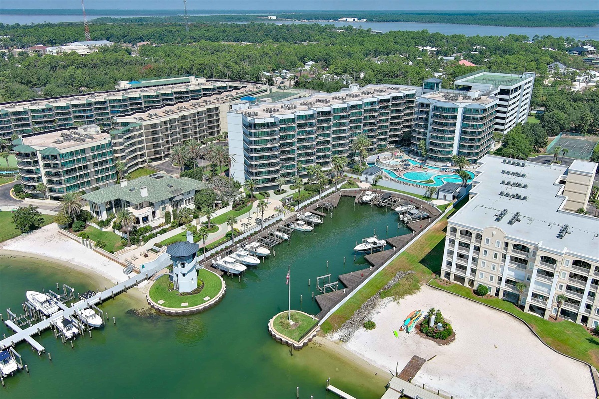 Lighthouse on the Bay II: A breathtaking aerial perspective showcasing an exclusive waterfront community. Featuring a private marina, pristine bay access, and luxurious residences surrounded by lush landscapes. Experience unparalleled coastal living.