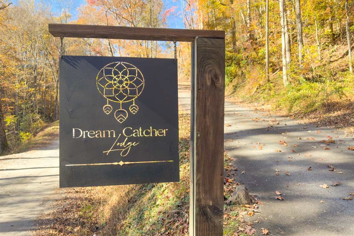 Entrance to the property with a paved road. Small packed gravel section to get to the driveway.