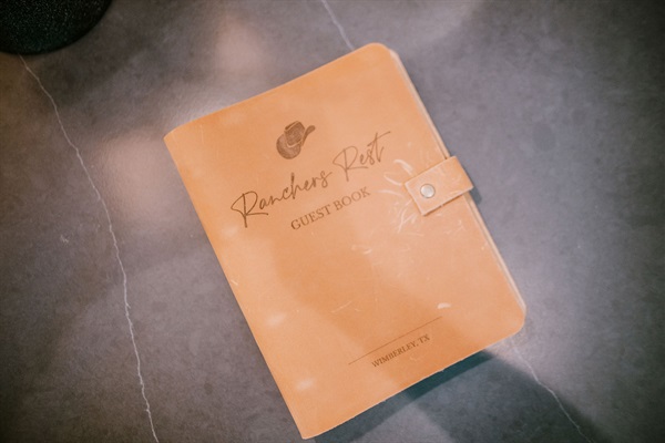 The Rancher's Rest guestbook &mdash; leave a note for the next traveler in a leather-bound keepsake at Gaines Ranch on the Square.
