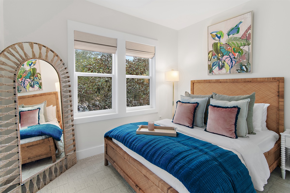 The upstairs queen bedroom is a lovely bright space nestled into the magnolia and oak trees in the front yard.