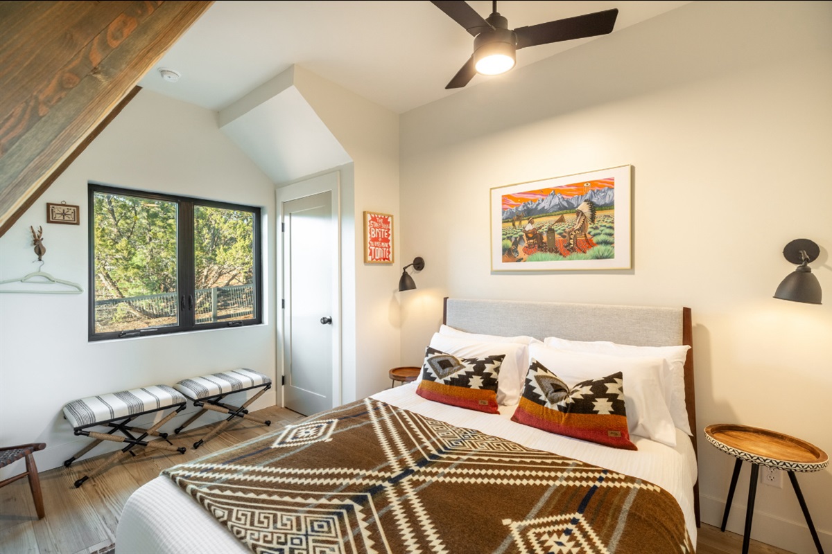 Main Floor bedroom with queen bed, blackout shades