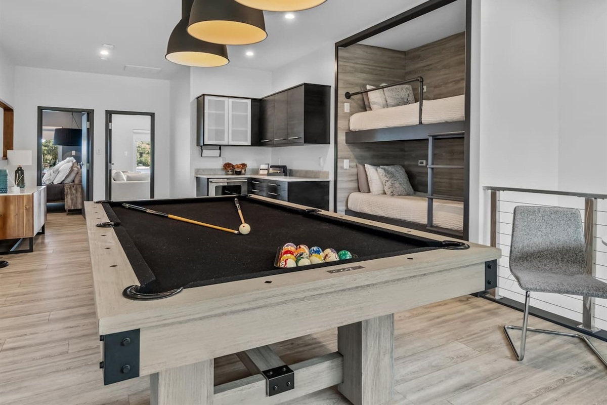 Pool table with beverage center and bunks in same room.